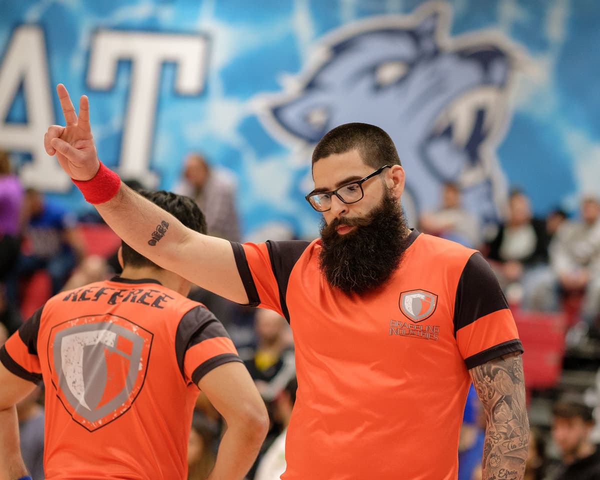 Greg Baugues / Grapplings (@grapplingsdotcom), Grappling Industries Manhattan, January 2020 A Grappling Industries referee raises two fingers while officiating at the January 2020 Manhattan tournament
