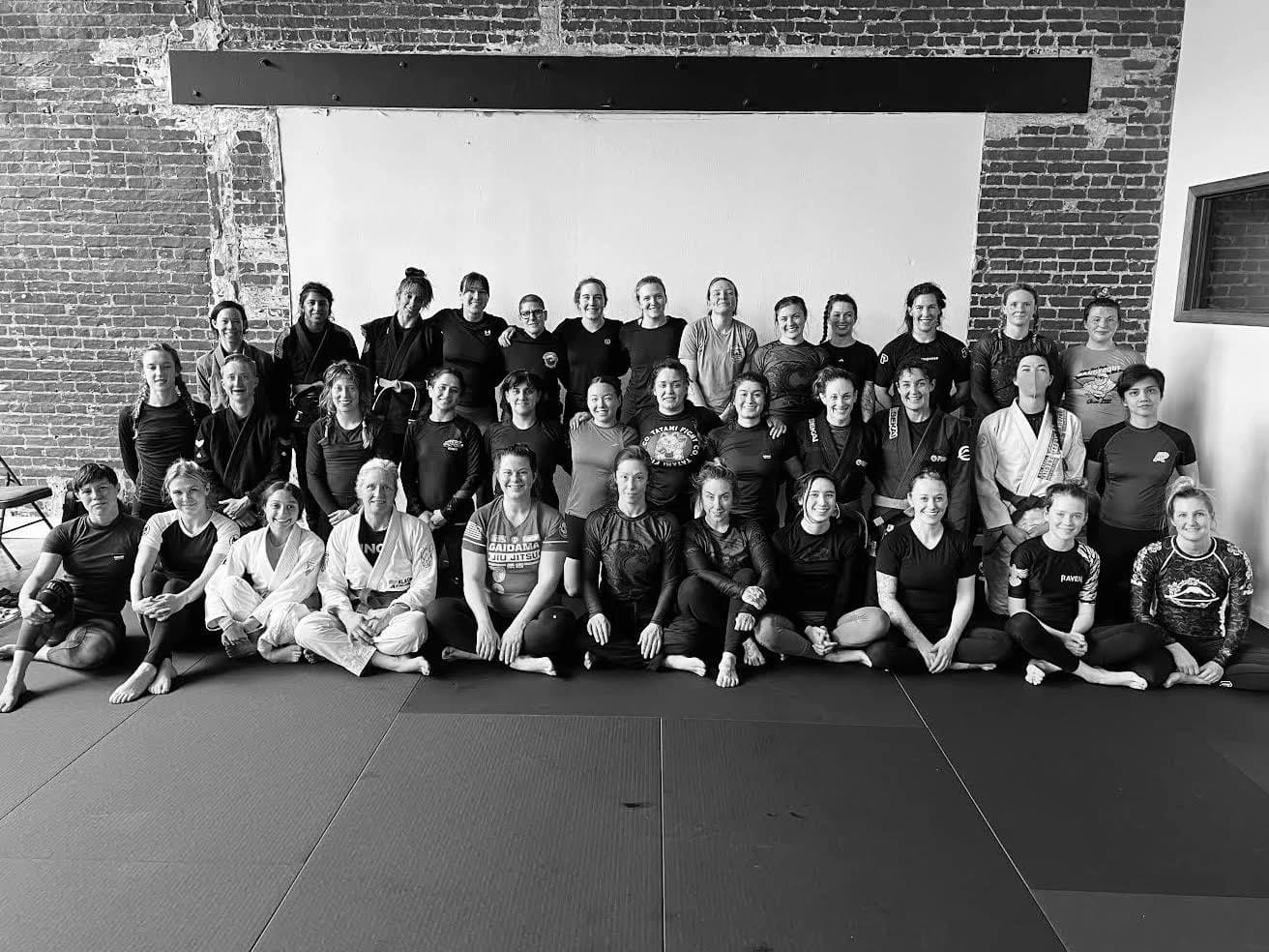 Women in training clothes posing together at Oregon Grappling Arts.
