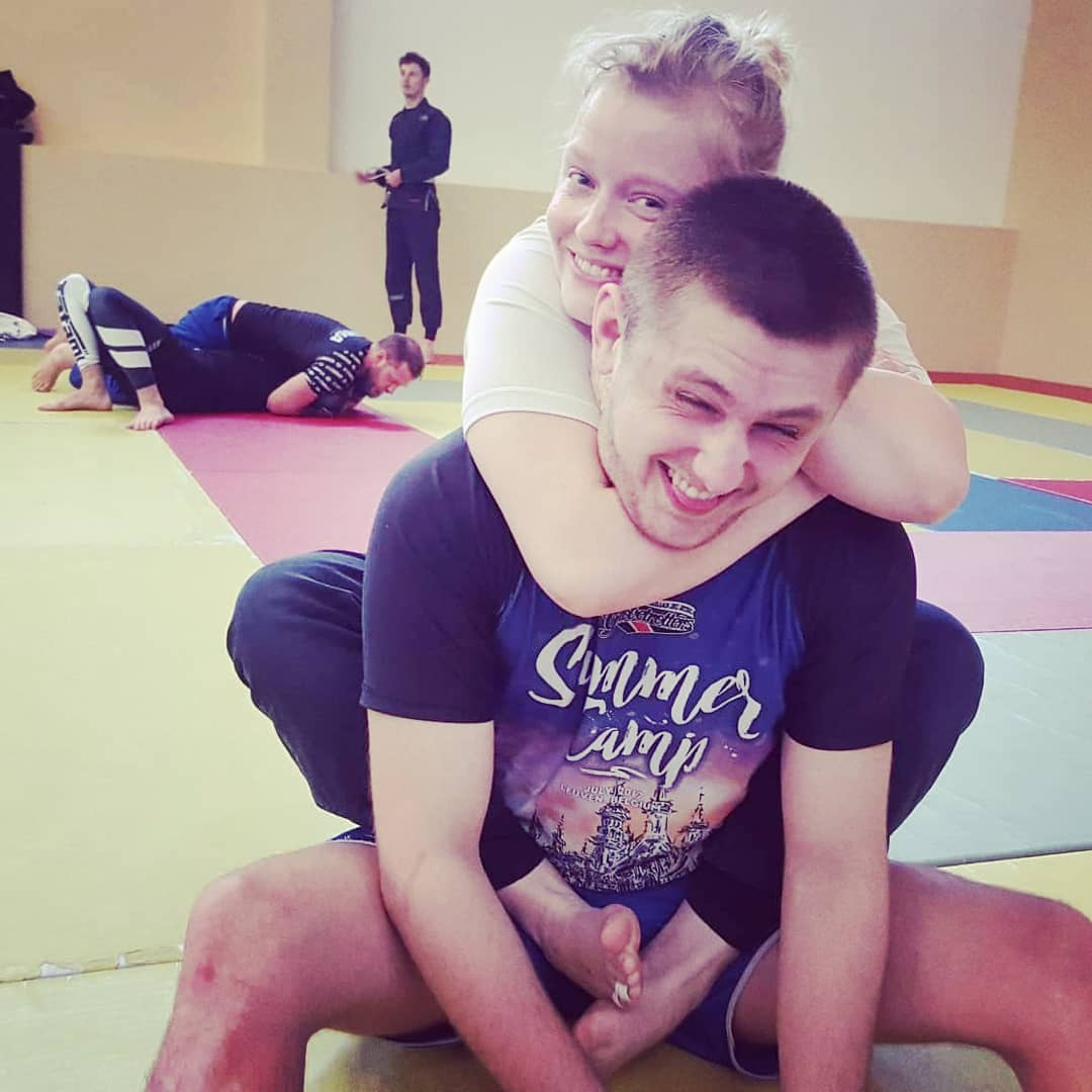 Two smiling practitioners posing playfully at an academy