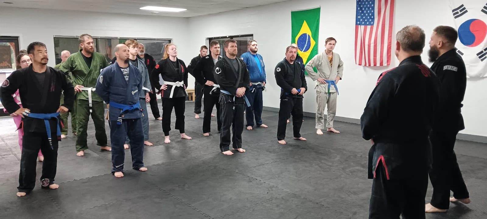 A group of students in gi uniforms attending a class at Absolute Martial Arts in Pickens, SC, with flags on the wall.